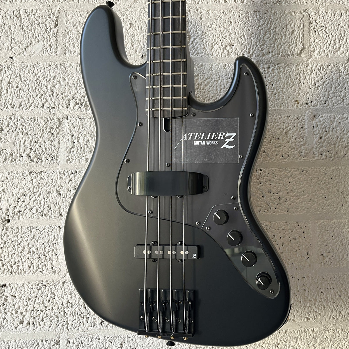 Atelier Z M#245 Custom 4-string bass in Matt Black with matching headstock and black hardware body closeup